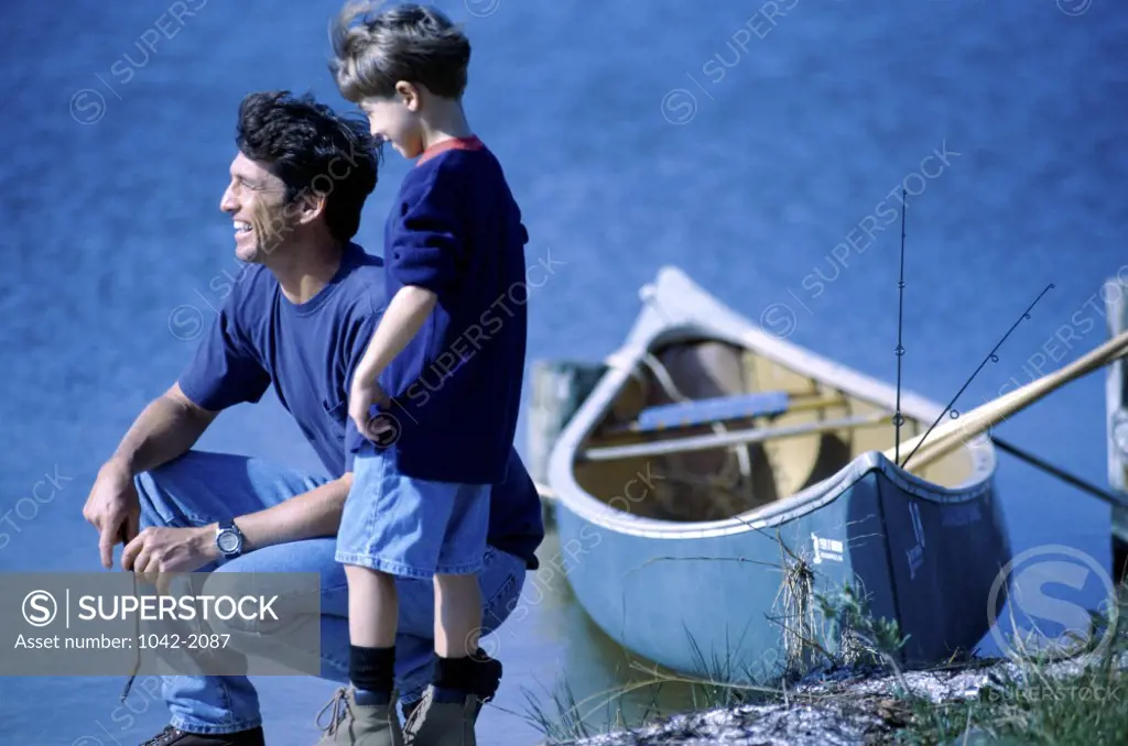 Father and his son beside a lake