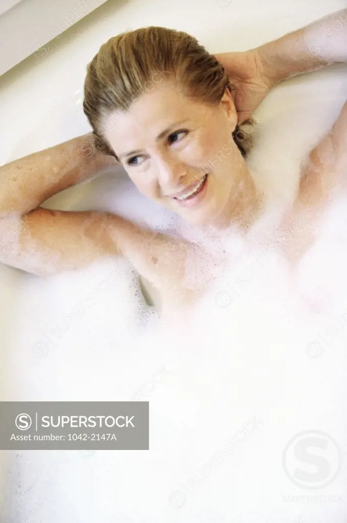Mid adult woman lying in a bathtub