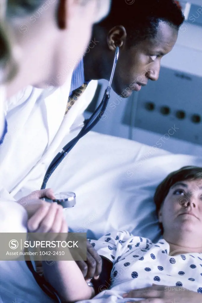 Male doctor checking a female patient's pulse