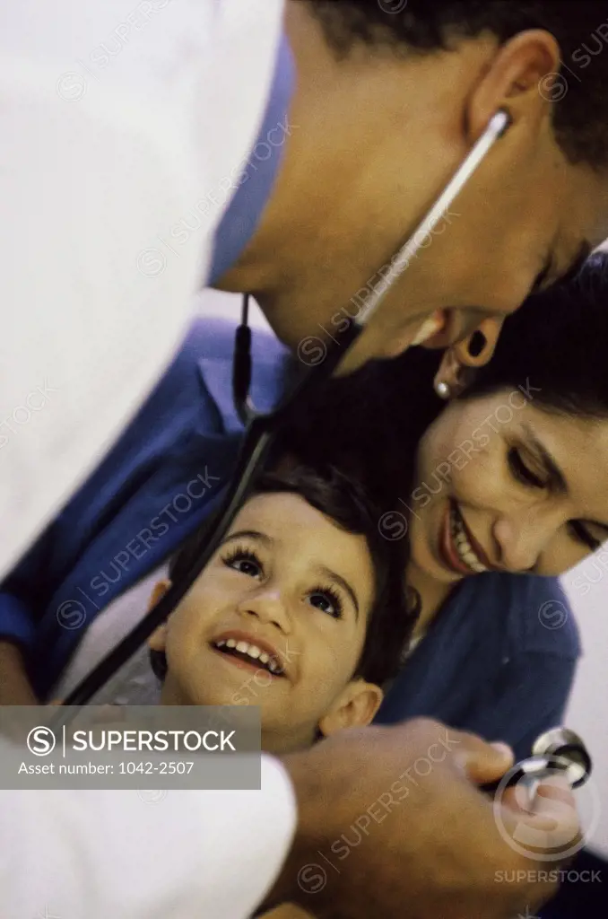 Male doctor examining a boy with a stethoscope