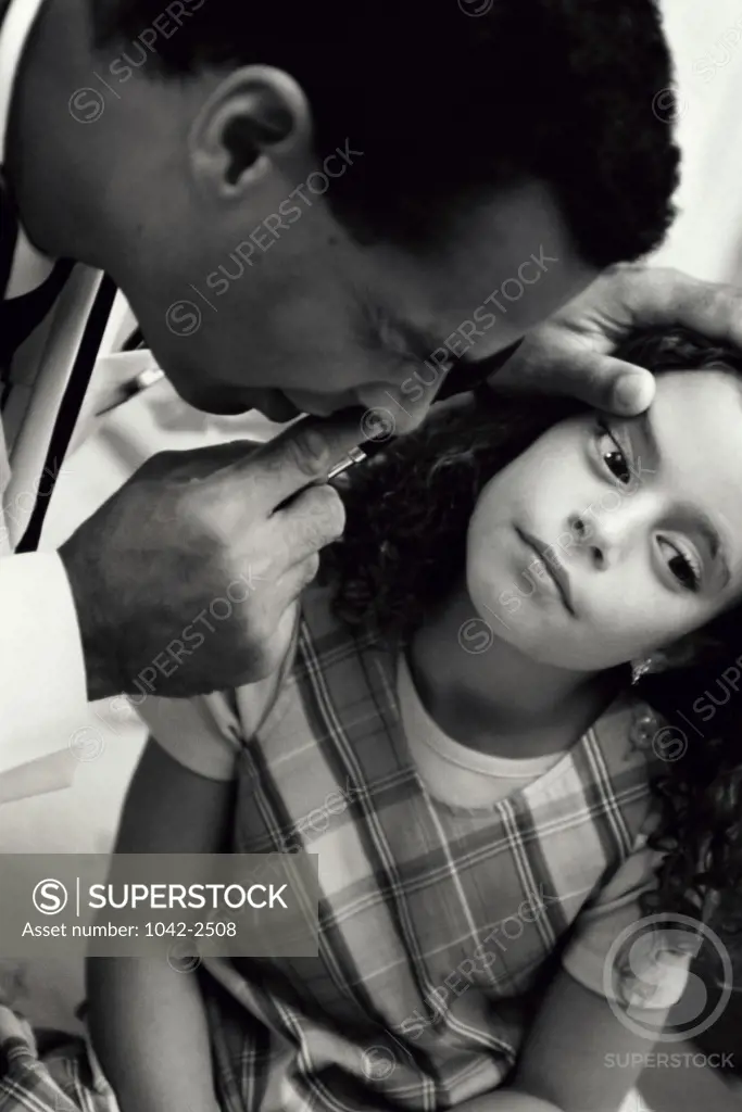 Male doctor examining a girl's eyes
