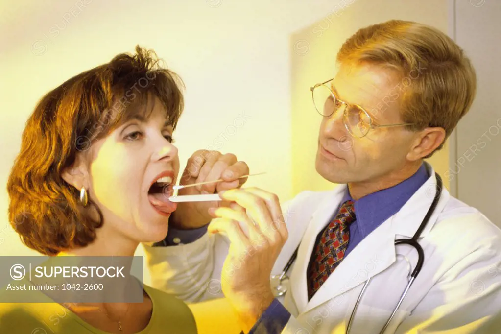 Close-up of a male doctor examining a female patient's mouth