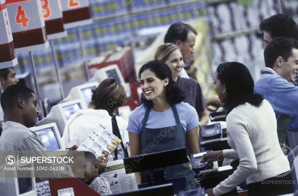 Cashier standing at a checkout counter in a supermarket