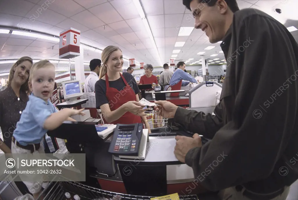 Customer paying a cashier at a checkout counter in a supermarket