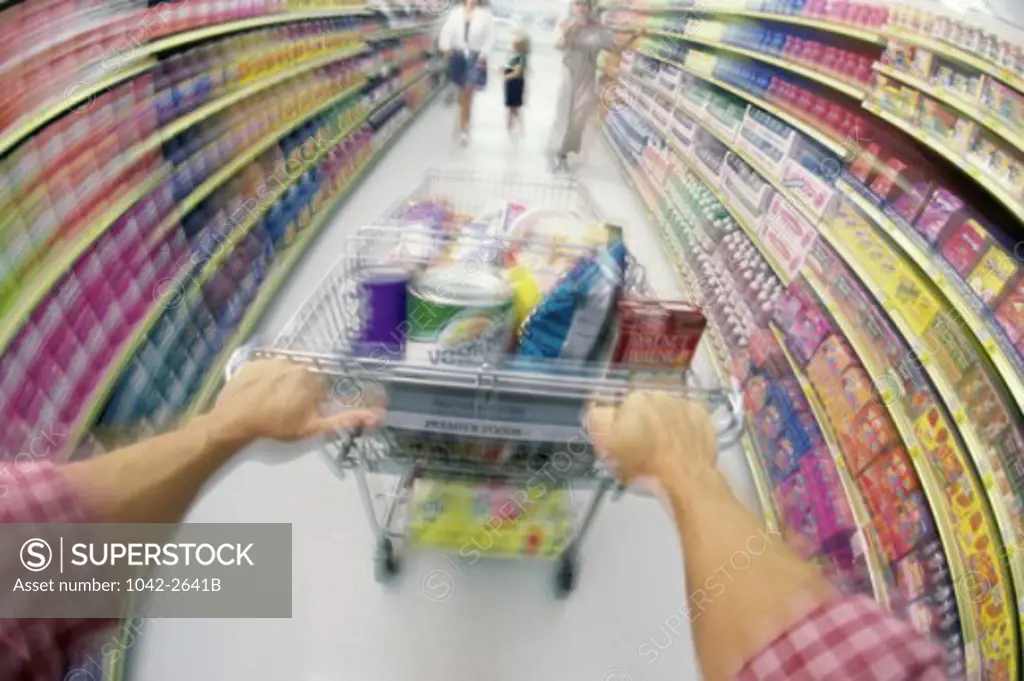 Man pushing a shopping cart in a supermarket
