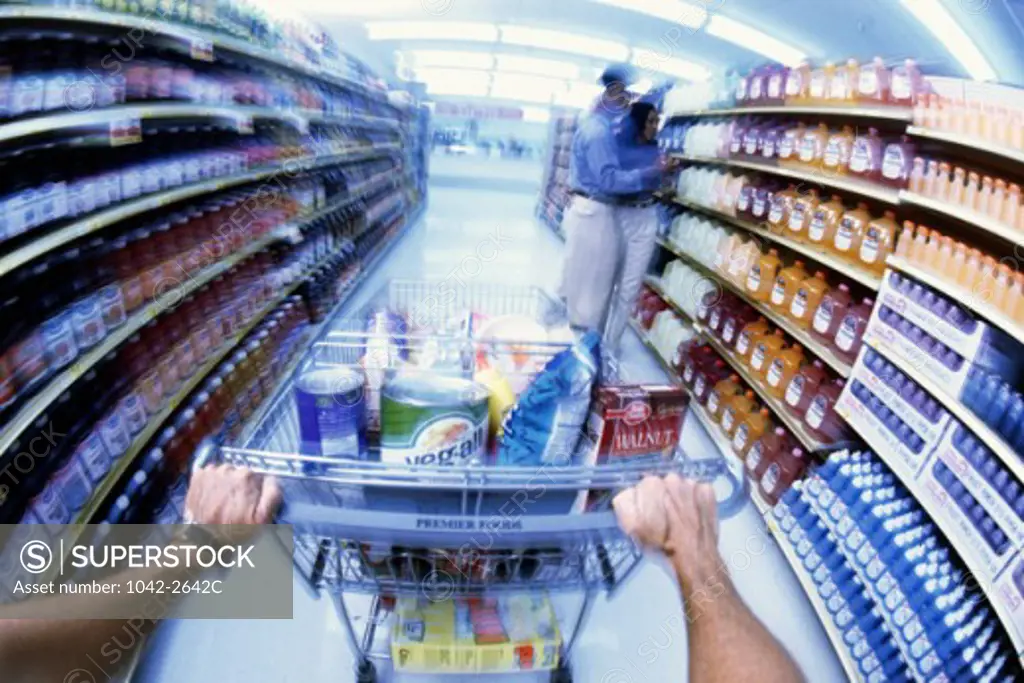 Man pushing a shopping cart in a supermarket