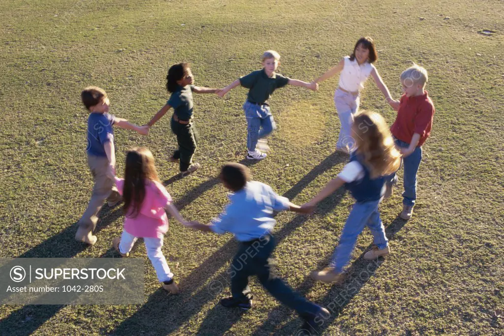 High angle view of a group of children playing ring-around-the-rosy