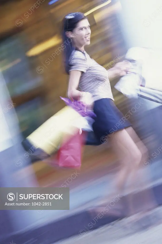 Side profile of a young woman carrying shopping bags