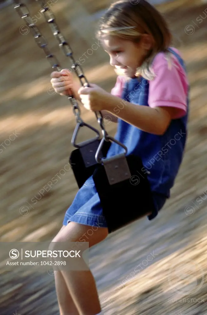 Side profile of a girl swinging on a swing