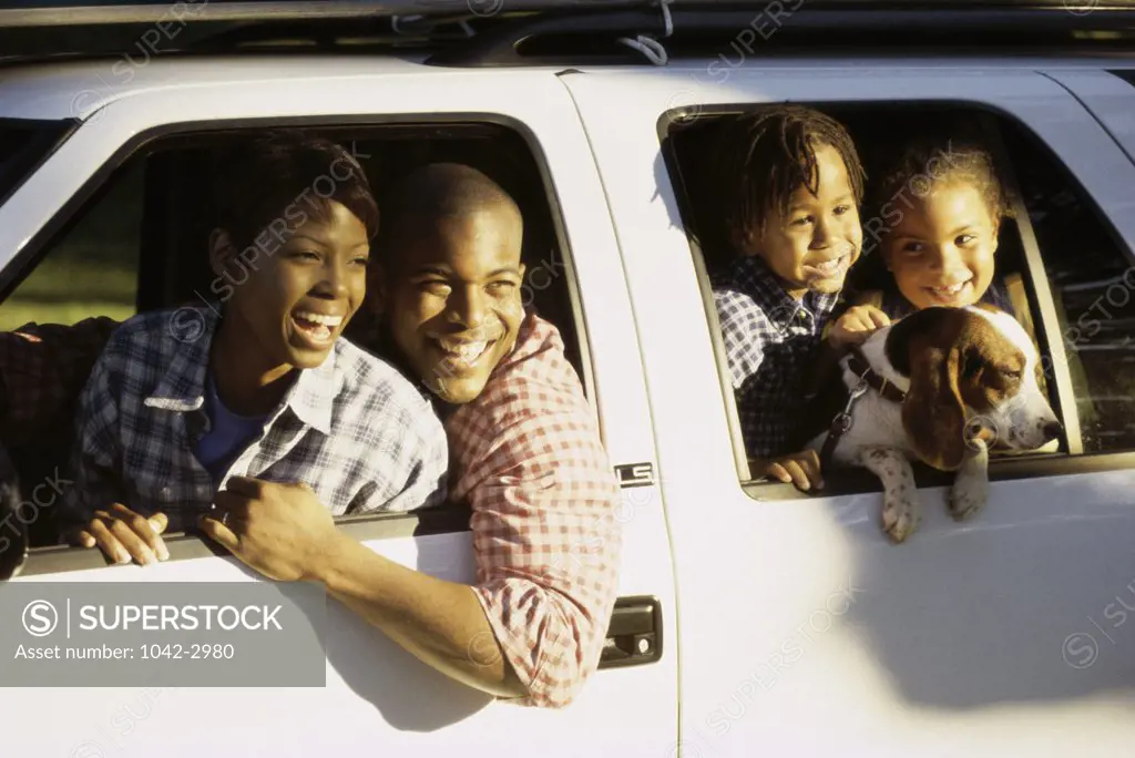 Parents sitting in a car with their son and daughter