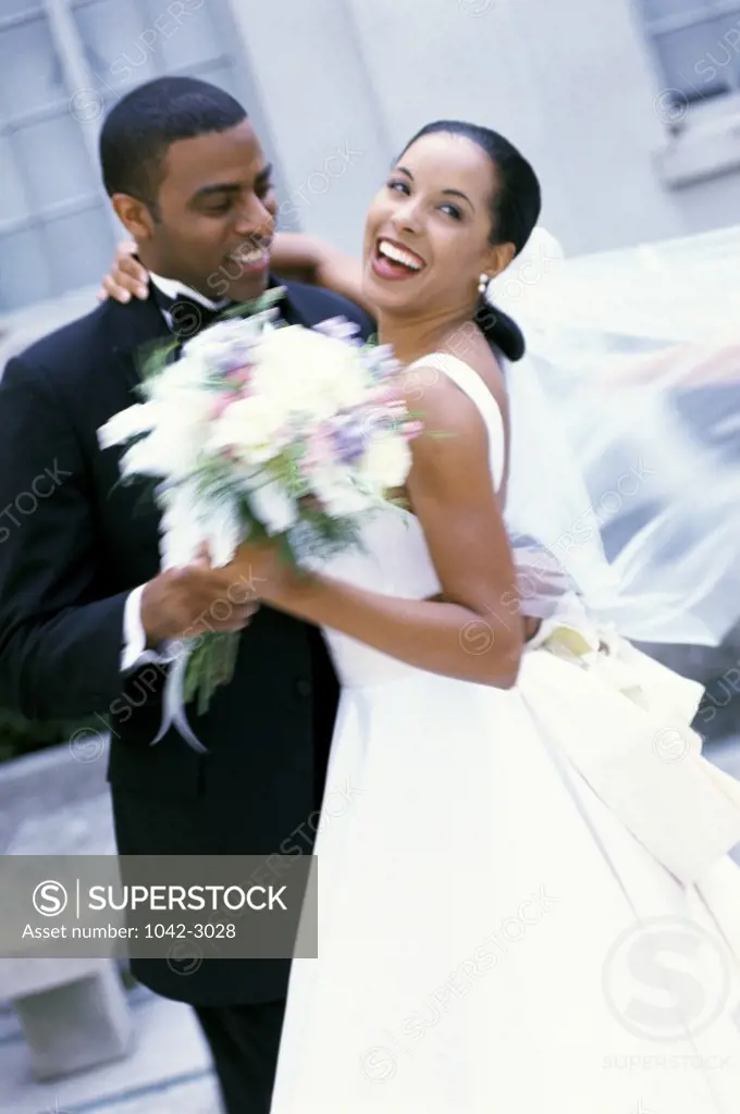 Newlywed couple holding a bouquet of flowers