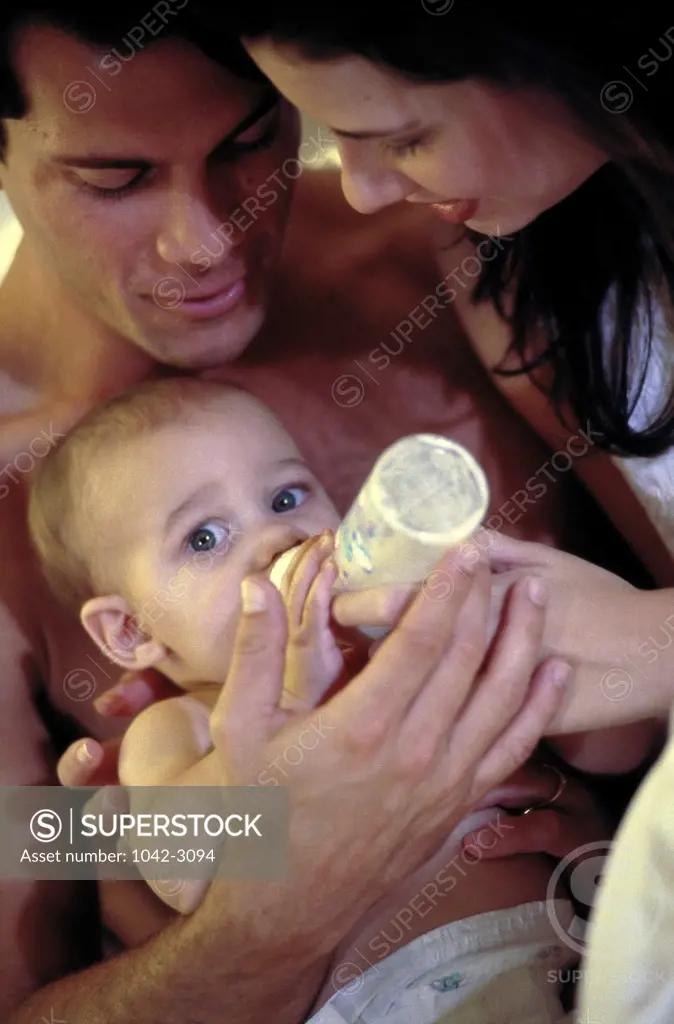 Parents feeding their baby boy
