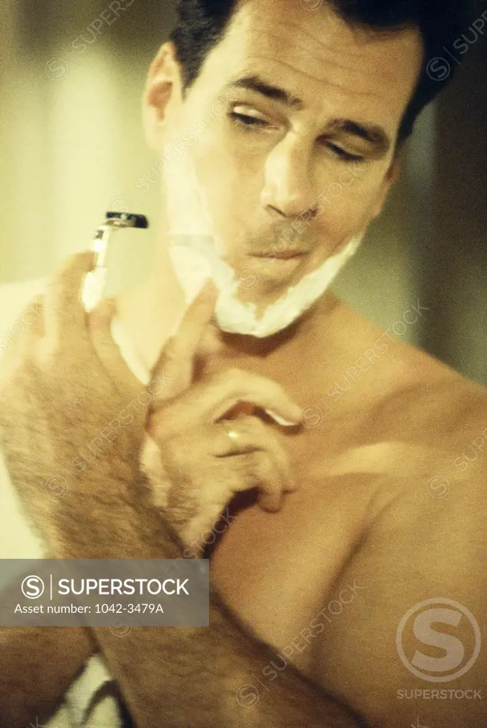Mid adult man shaving