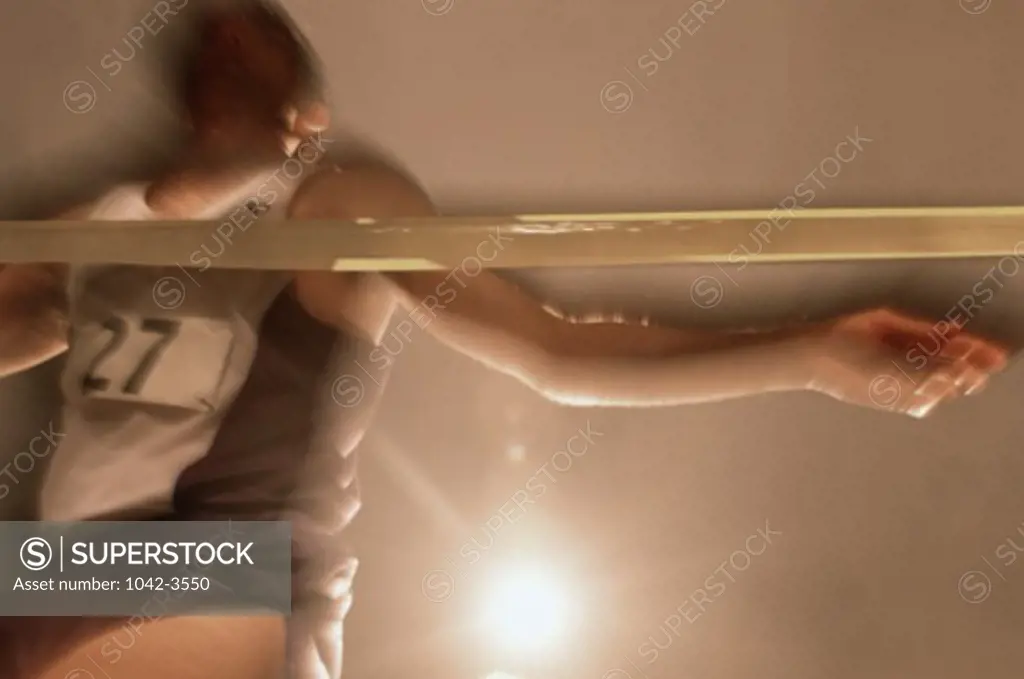 Low angle view of a mid adult man crossing the finish line