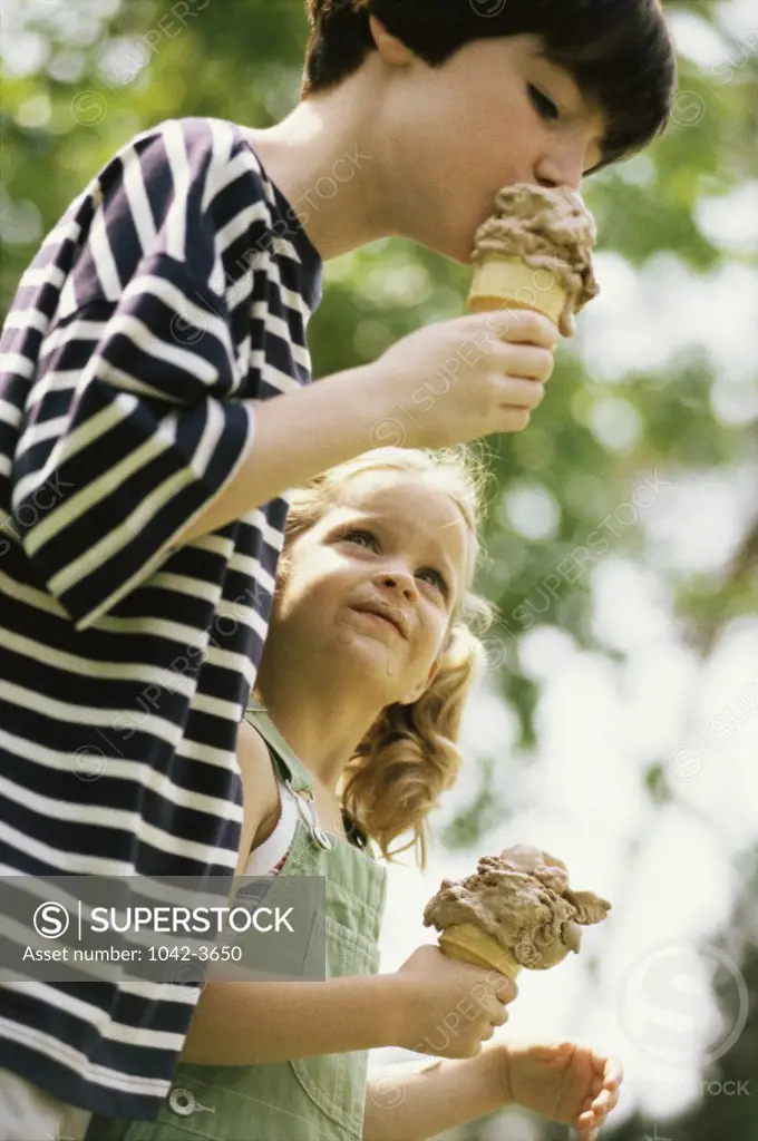Side profile of a girl and a boy eating ice cream cones