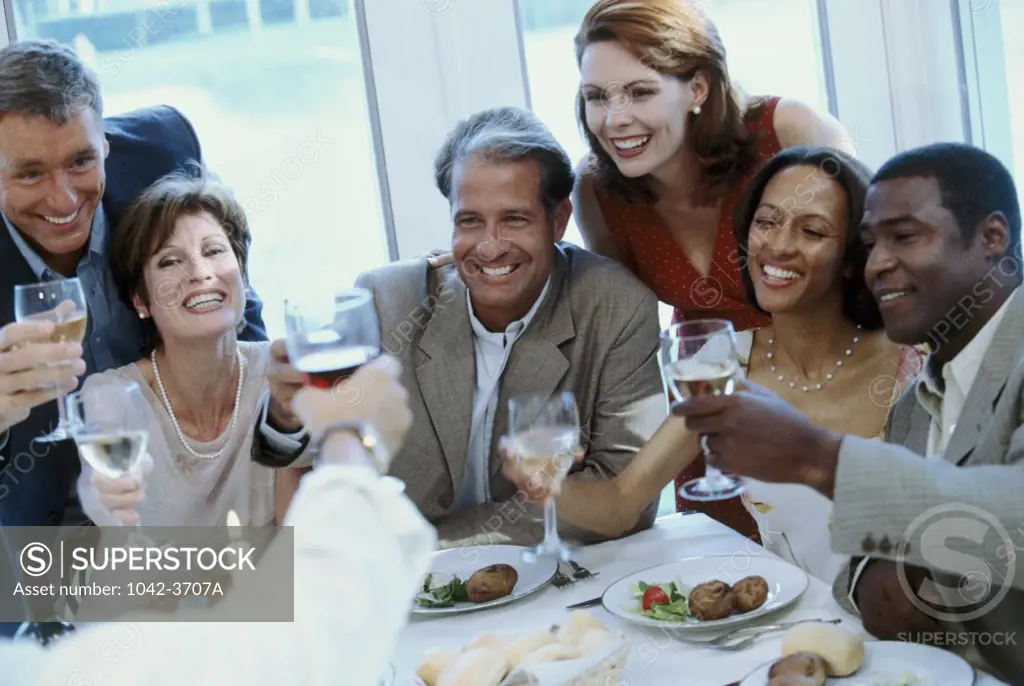 Group of men and women toasting with wineglasses