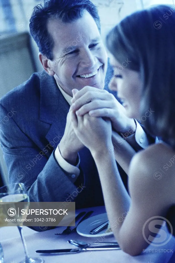 Mid adult couple sitting together holding hands