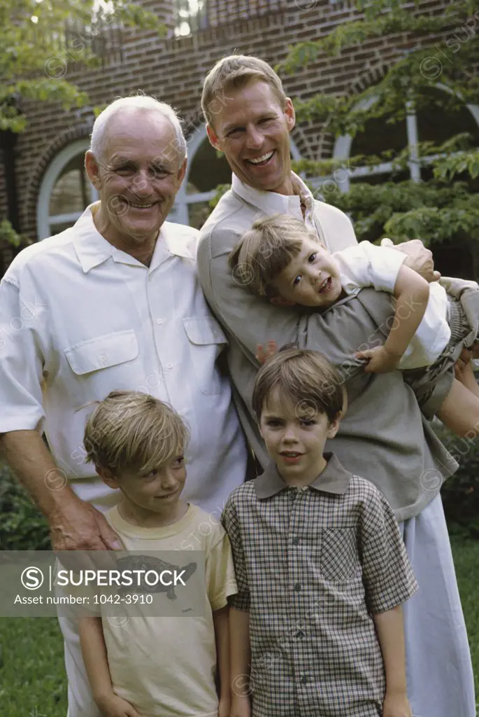 Grandfather standing with his son and three grandchildren