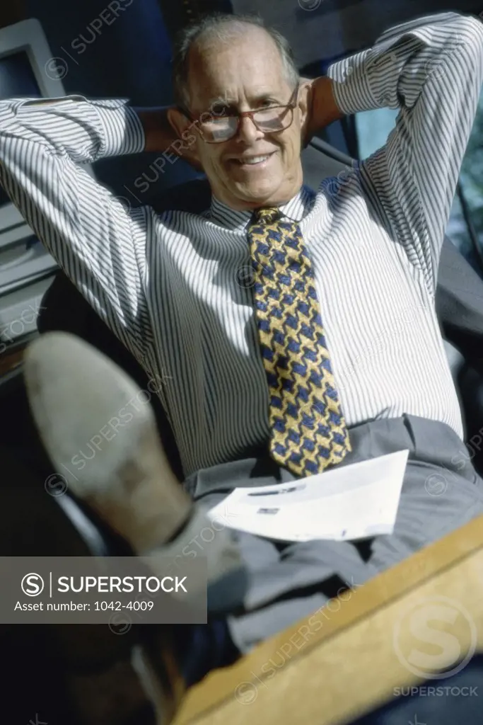 Portrait of a businessman with his feet up on a desk