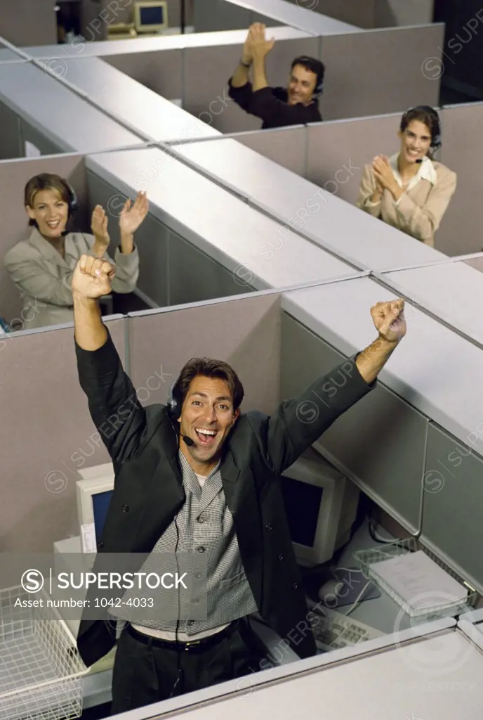 Group of business executives in cubicles wearing headsets