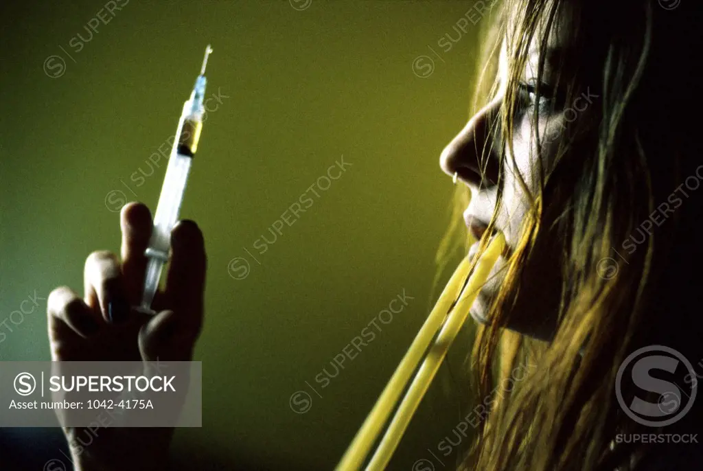 Side profile of a young woman holding a syringe