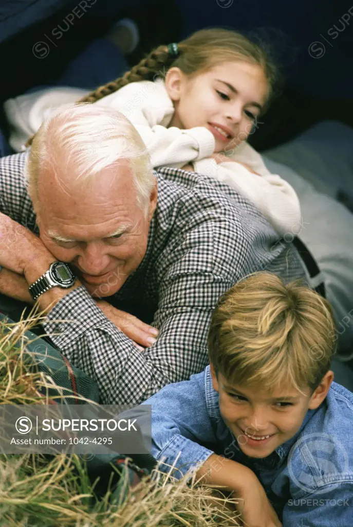 Grandfather lying down with his grandson and granddaughter