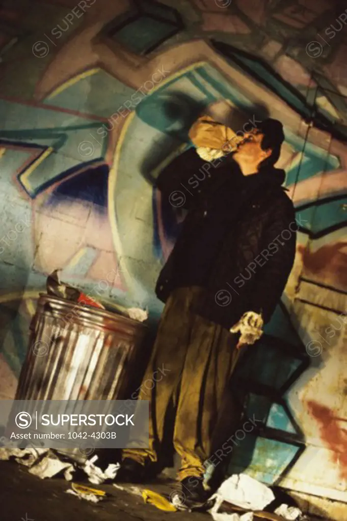 Mature man standing near a garbage can