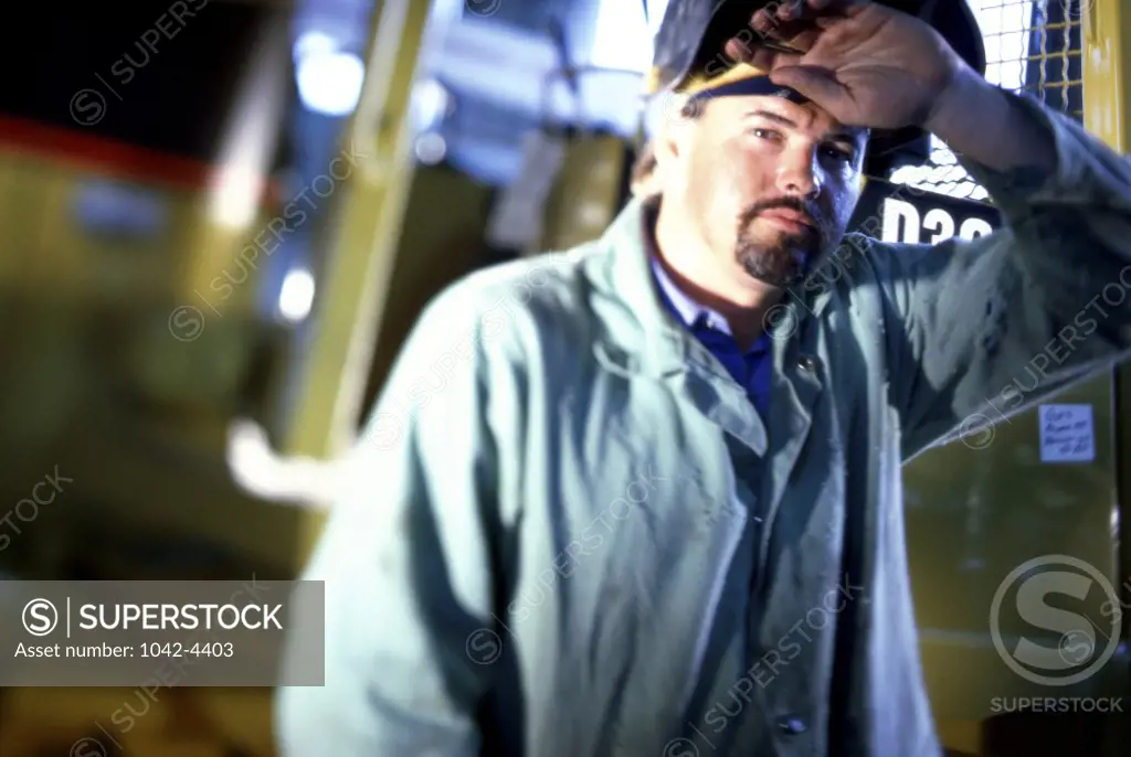 Portrait of a welder wiping his forehead with his hand