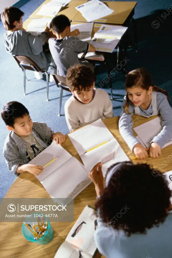 High angle view of a teacher holding flashcards in front of her students