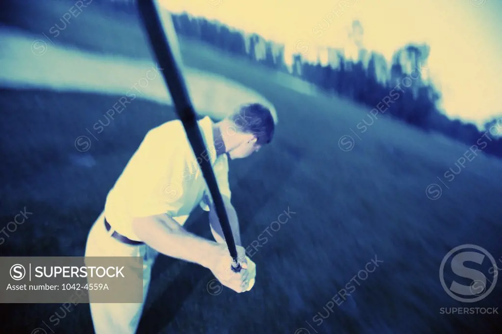 High angle view of a mid adult man swinging a golf club