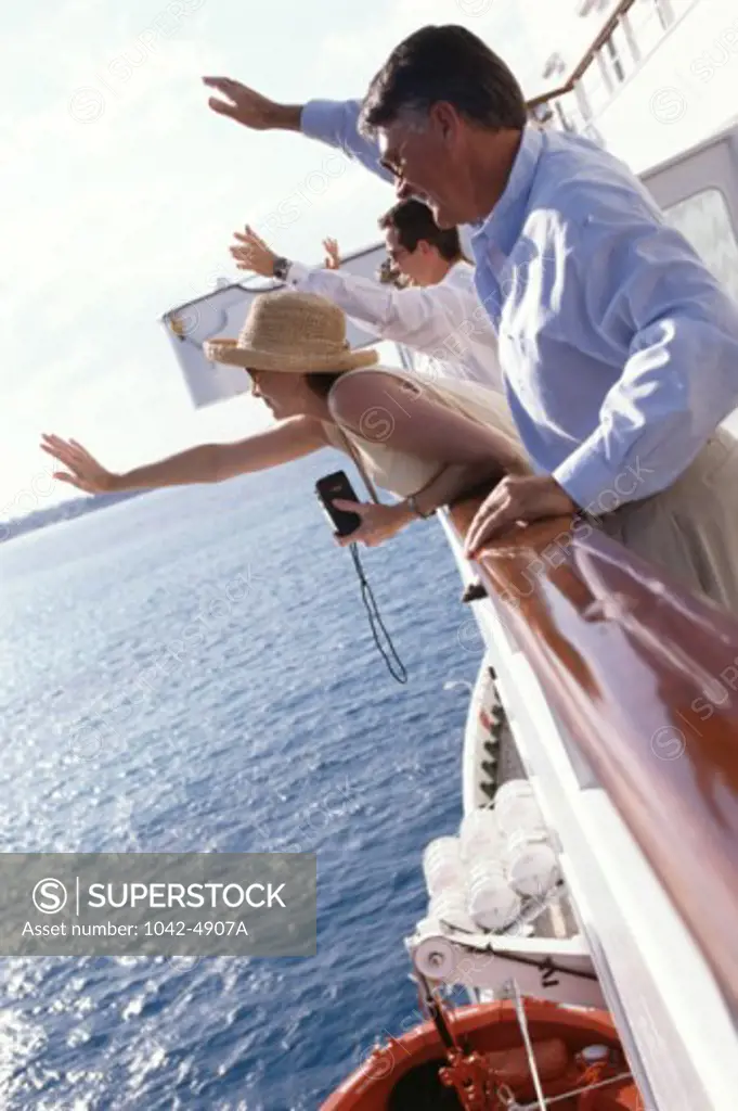 Side profile of a group of people standing on a cruise ship waving