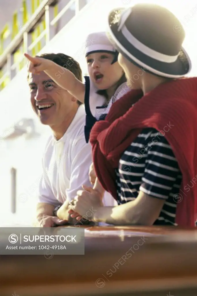 Side view of a young couple standing with their daughter on a cruise ship