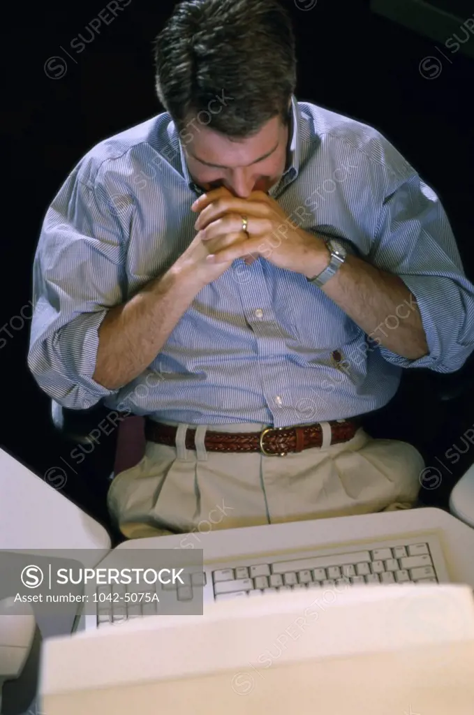 High angle view of a businessman sitting in front of a computer monitor in an office