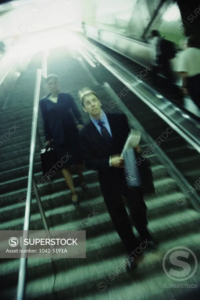 Businessman and a businesswoman walking down a staircase