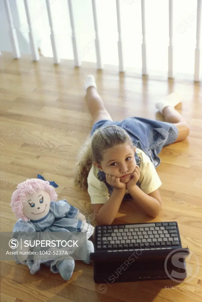 Portrait of a girl lying on the floor in front of a laptop