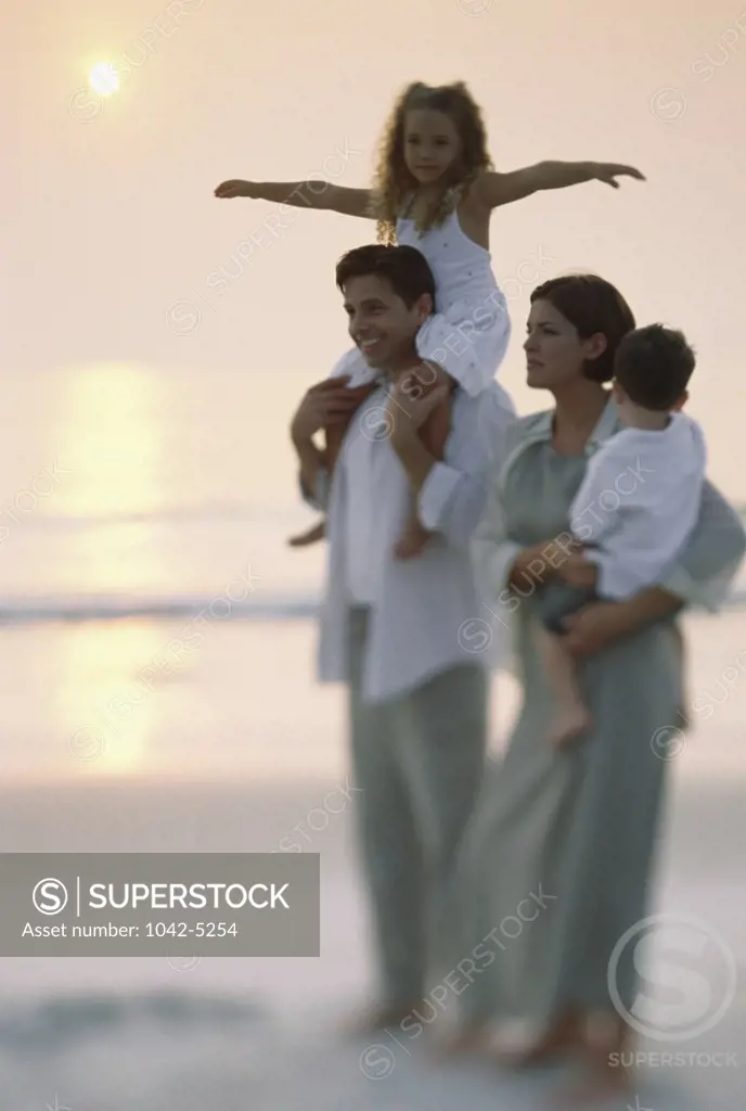 Young couple with their son and daughter on the beach