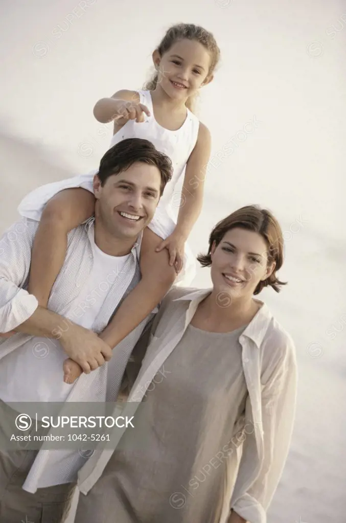 Young couple with their daughter on the beach