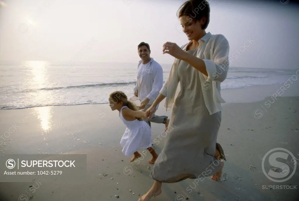 Young couple on the beach with their daughter
