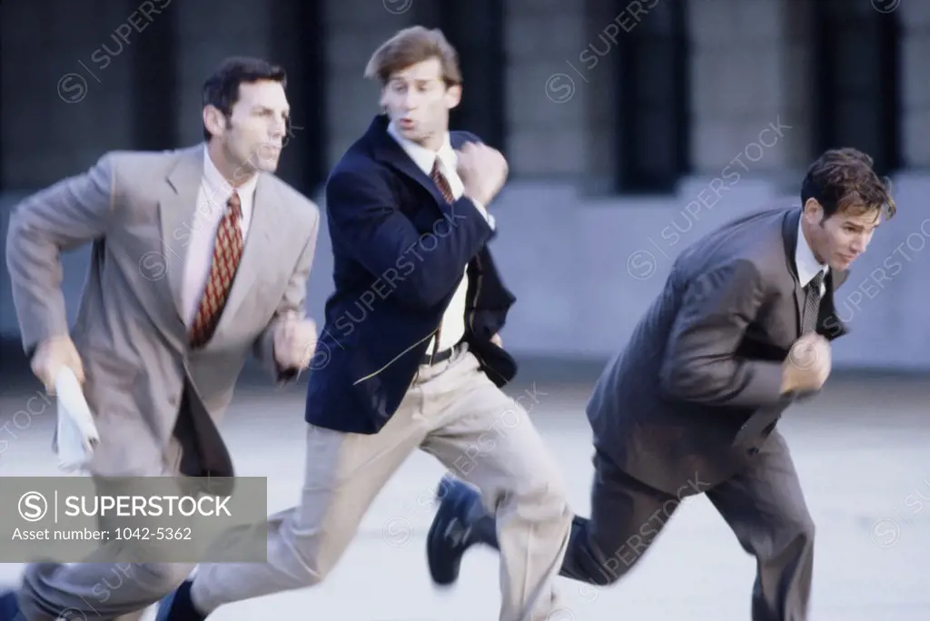 Three businessmen running