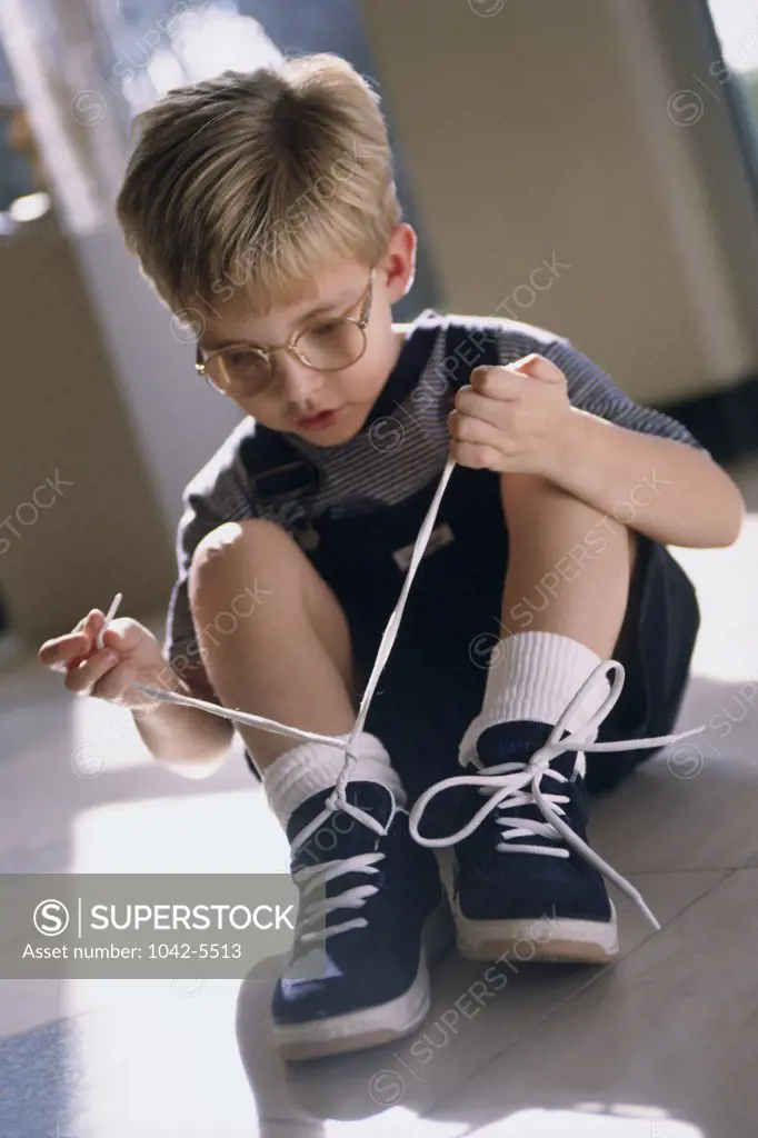 Close-up of a boy tying his shoelaces
