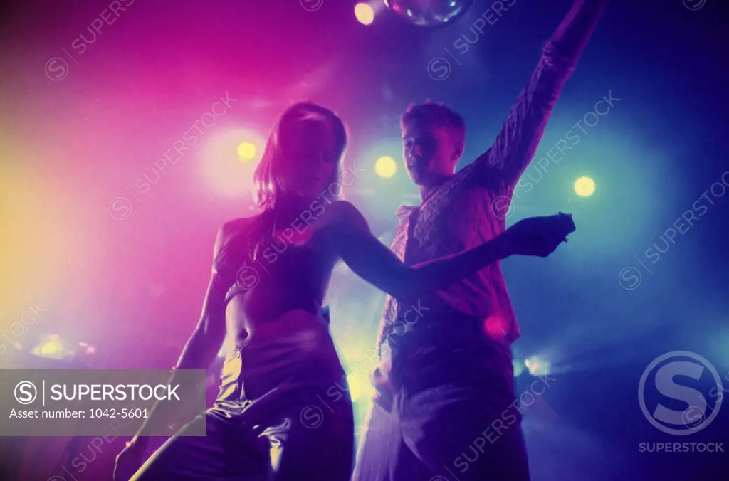 Low angle view of a teenage couple dancing at a nightclub