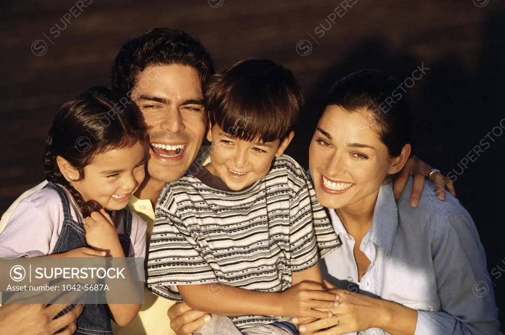 Portrait of a mid adult couple with their son and daughter smiling