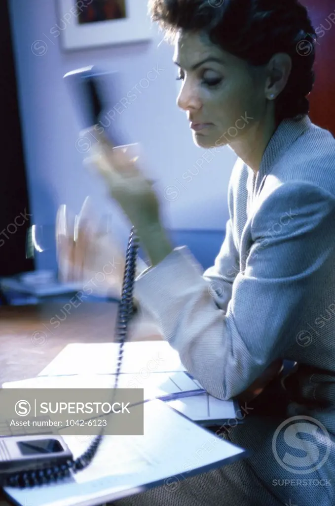 Side profile of a businesswoman holding a telephone receiver