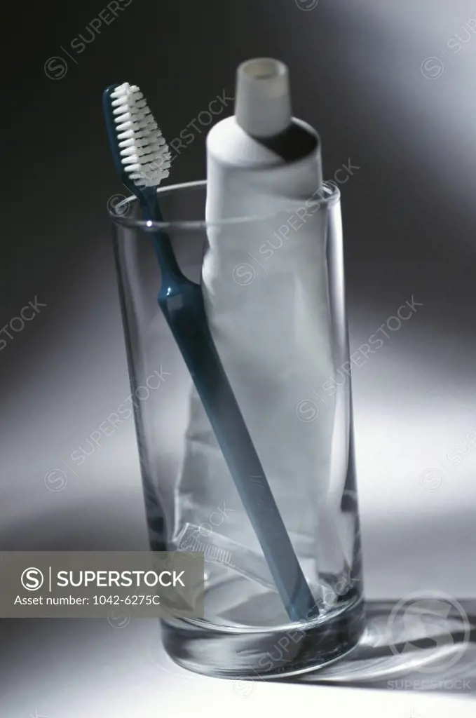 Toothbrush and a tube of toothpaste in a glass
