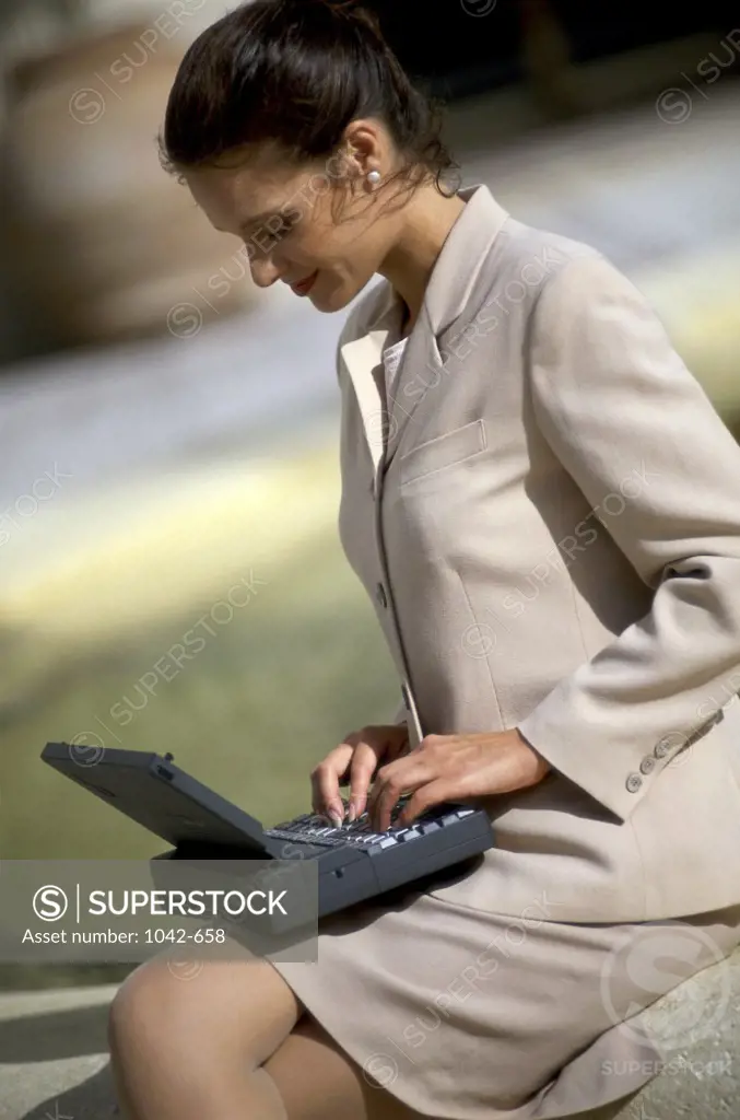 Side profile of a businesswoman sitting using a laptop