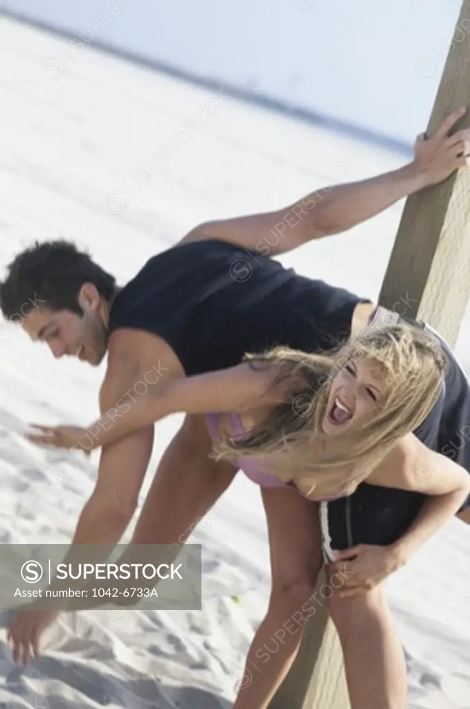 Young couple playing on the beach