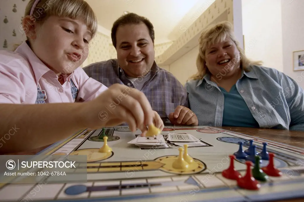 Parents and their daughter playing a board game