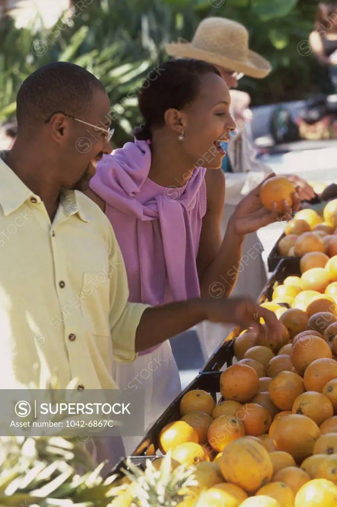 Mid adult couple choosing fruit at a fruit stand