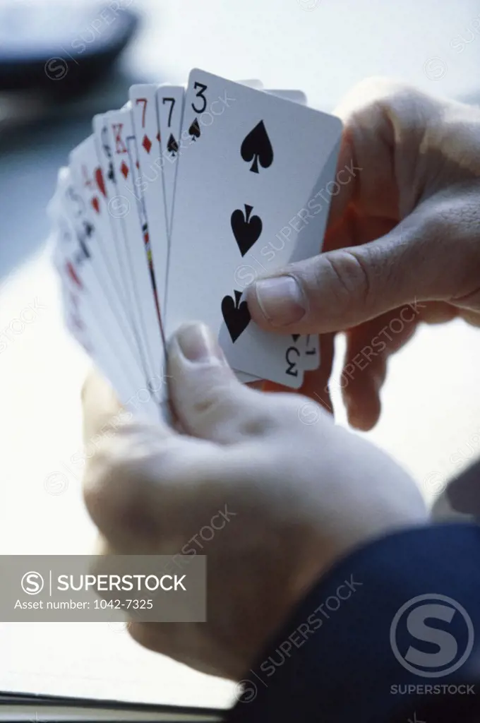 Person's hand holding playing cards