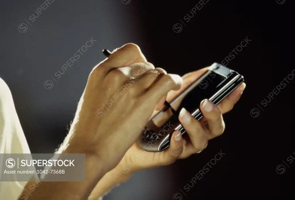 Close-up of a person's hand operating a hand held device